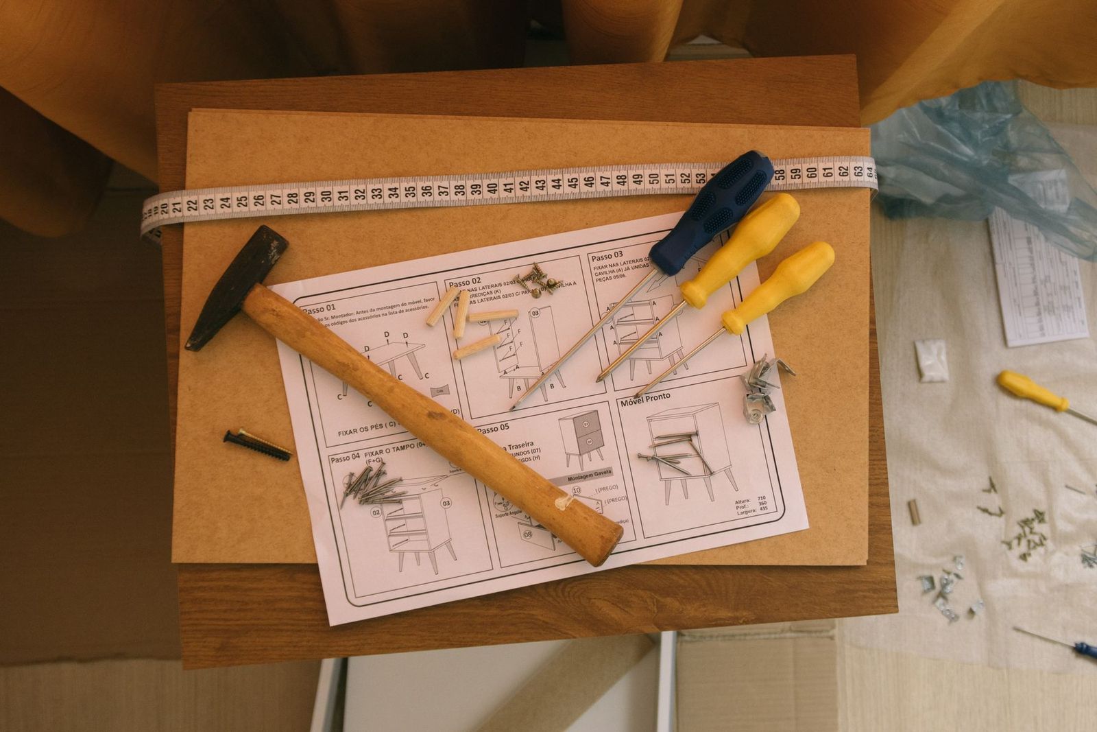 Aufbauanleitung auf Papier mit Schraubendrehern und Hammer, von oben